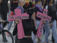A member of the feminist Black Bloc holds two pink crosses in the Zócalo in Mexico City to mark the International Day for the Elimination of...