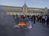 Members of the feminist Black Bloc burn banners and posters while demonstrating in Mexico City's Zócalo to mark the International Day for th...