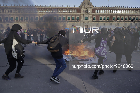 Members of the feminist Black Bloc burn banners and posters while demonstrating in Mexico City's Zócalo to mark the International Day for th...