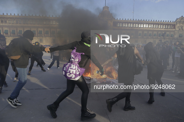 Members of the feminist Black Bloc burn banners and posters while demonstrating in Mexico City's Zócalo to mark the International Day for th...