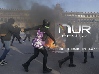 Members of the feminist Black Bloc burn banners and posters while demonstrating in Mexico City's Zócalo to mark the International Day for th...