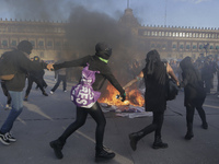 Members of the feminist Black Bloc burn banners and posters while demonstrating in Mexico City's Zócalo to mark the International Day for th...