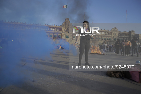 A member of the feminist Black Bloc burns a flare in the Zócalo in Mexico City to mark the International Day for the Elimination of Violence...