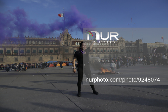 A member of the feminist Black Bloc burns a flare in the Zócalo in Mexico City to mark the International Day for the Elimination of Violence...