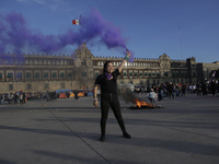 A member of the feminist Black Bloc burns a flare in the Zócalo in Mexico City to mark the International Day for the Elimination of Violence...