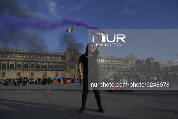 A member of the feminist Black Bloc burns a flare in the Zócalo in Mexico City to mark the International Day for the Elimination of Violence...