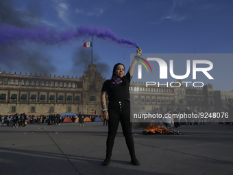 A member of the feminist Black Bloc burns a flare in the Zócalo in Mexico City to mark the International Day for the Elimination of Violence...