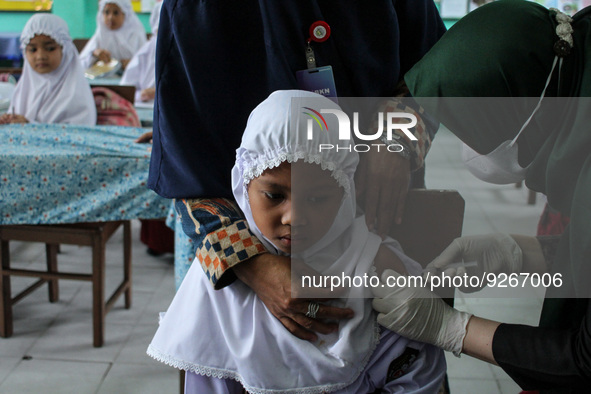 A Health workers inject students with the Diphtheria and Tetanus vaccines during child immunization at an elementary school in Lhokseumawe C...