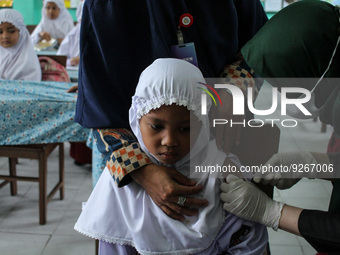 A Health workers inject students with the Diphtheria and Tetanus vaccines during child immunization at an elementary school in Lhokseumawe C...