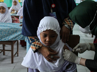 A Health workers inject students with the Diphtheria and Tetanus vaccines during child immunization at an elementary school in Lhokseumawe C...