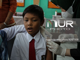 A Health workers inject students with the Diphtheria and Tetanus vaccines during child immunization at an elementary school in Lhokseumawe C...