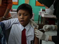 A Health workers inject students with the Diphtheria and Tetanus vaccines during child immunization at an elementary school in Lhokseumawe C...