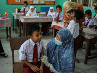 A health worker prepares an injection of the Diphtheria and Tetanus vaccines during child immunization at an elementary school in Lhokseumaw...