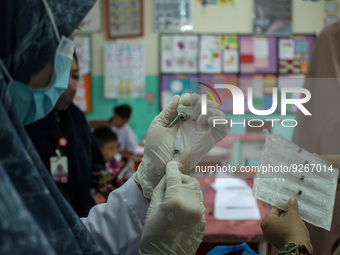 A health worker prepares an injection of the Diphtheria and Tetanus vaccines during child immunization at an elementary school in Lhokseumaw...