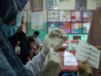 A health worker prepares an injection of the Diphtheria and Tetanus vaccines during child immunization at an elementary school in Lhokseumaw...