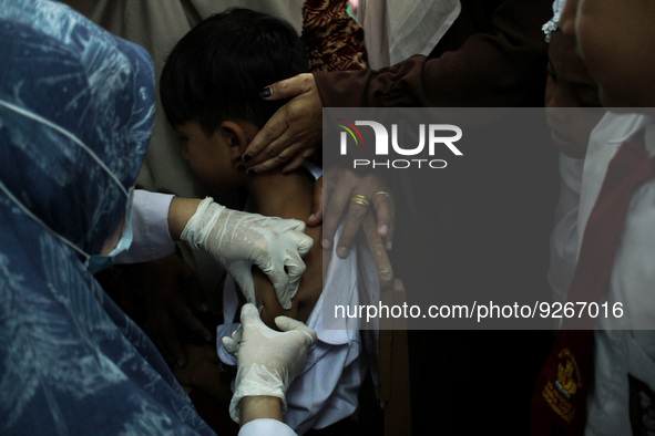 A Health workers inject students with the Diphtheria and Tetanus vaccines during child immunization at an elementary school in Lhokseumawe C...