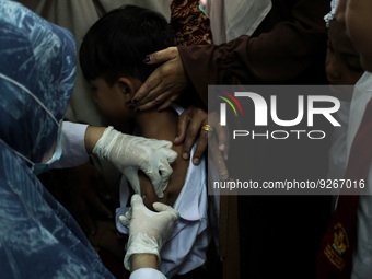 A Health workers inject students with the Diphtheria and Tetanus vaccines during child immunization at an elementary school in Lhokseumawe C...