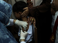 A Health workers inject students with the Diphtheria and Tetanus vaccines during child immunization at an elementary school in Lhokseumawe C...