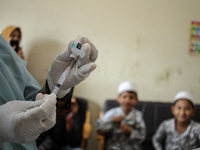 A health worker prepares an injection of the Diphtheria and Tetanus vaccines during child immunization at an elementary school in Lhokseumaw...