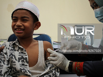 A Health workers inject students with the Diphtheria and Tetanus vaccines during child immunization at an elementary school in Lhokseumawe C...