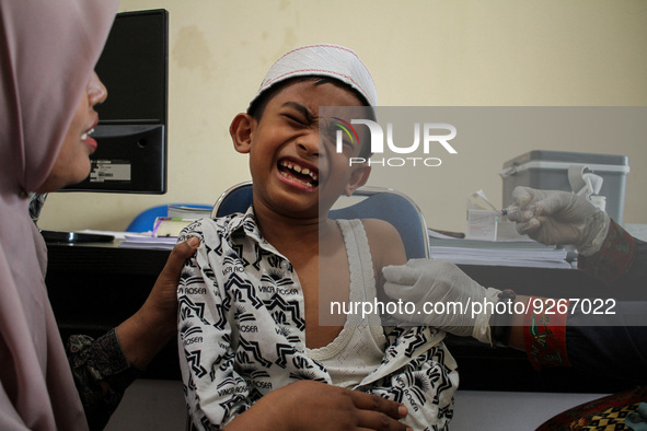 A Health workers inject students with the Diphtheria and Tetanus vaccines during child immunization at an elementary school in Lhokseumawe C...