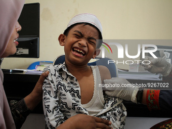 A Health workers inject students with the Diphtheria and Tetanus vaccines during child immunization at an elementary school in Lhokseumawe C...