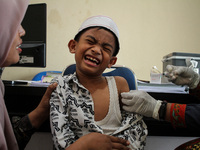 A Health workers inject students with the Diphtheria and Tetanus vaccines during child immunization at an elementary school in Lhokseumawe C...