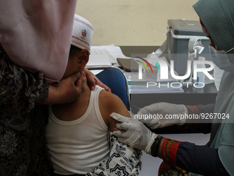 A Health workers inject students with the Diphtheria and Tetanus vaccines during child immunization at an elementary school in Lhokseumawe C...