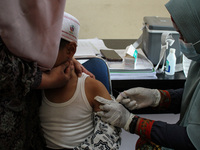 A Health workers inject students with the Diphtheria and Tetanus vaccines during child immunization at an elementary school in Lhokseumawe C...