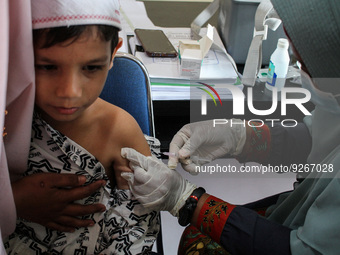 A Health workers inject students with the Diphtheria and Tetanus vaccines during child immunization at an elementary school in Lhokseumawe C...