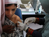 A Health workers inject students with the Diphtheria and Tetanus vaccines during child immunization at an elementary school in Lhokseumawe C...