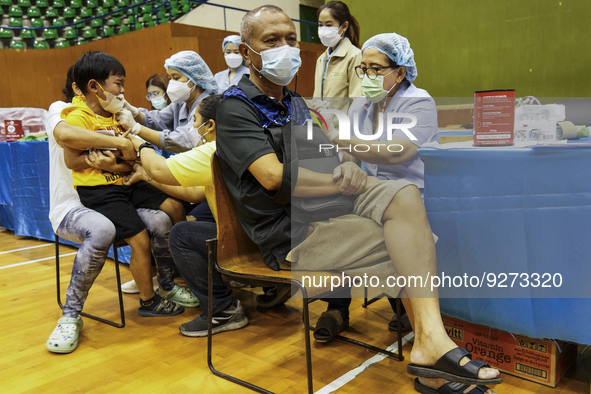 People receive doses of the Pfizer COVID-19 vaccine booster at a vaccination center inside a stadium in Bangkok, Thailand, 03 December 2022....