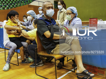 People receive doses of the Pfizer COVID-19 vaccine booster at a vaccination center inside a stadium in Bangkok, Thailand, 03 December 2022....