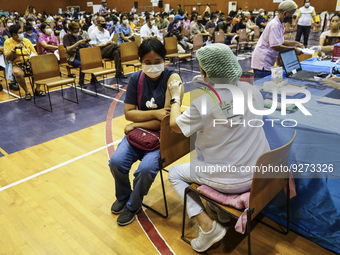 People receive doses of the Pfizer COVID-19 vaccine booster at a vaccination center inside a stadium in Bangkok, Thailand, 03 December 2022....