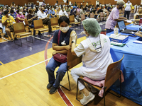 People receive doses of the Pfizer COVID-19 vaccine booster at a vaccination center inside a stadium in Bangkok, Thailand, 03 December 2022....