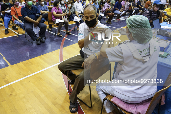 People receive doses of the Pfizer COVID-19 vaccine booster at a vaccination center inside a stadium in Bangkok, Thailand, 03 December 2022....