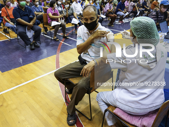 People receive doses of the Pfizer COVID-19 vaccine booster at a vaccination center inside a stadium in Bangkok, Thailand, 03 December 2022....