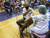 People receive doses of the Pfizer COVID-19 vaccine booster at a vaccination center inside a stadium in Bangkok, Thailand, 03 December 2022....