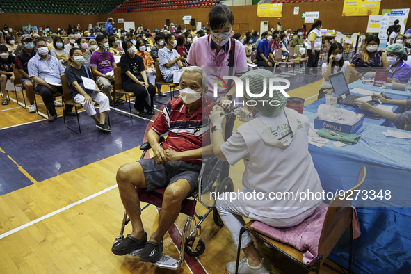 People receive doses of the Pfizer COVID-19 vaccine booster at a vaccination center inside a stadium in Bangkok, Thailand, 03 December 2022....