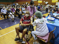 People receive doses of the Pfizer COVID-19 vaccine booster at a vaccination center inside a stadium in Bangkok, Thailand, 03 December 2022....