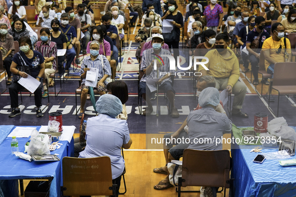 People receive doses of the Pfizer COVID-19 vaccine booster at a vaccination center inside a stadium in Bangkok, Thailand, 03 December 2022....