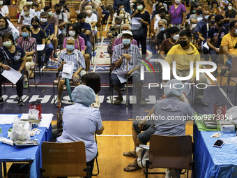 People receive doses of the Pfizer COVID-19 vaccine booster at a vaccination center inside a stadium in Bangkok, Thailand, 03 December 2022....