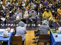 People receive doses of the Pfizer COVID-19 vaccine booster at a vaccination center inside a stadium in Bangkok, Thailand, 03 December 2022....