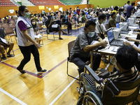 Thai people to  register to get vaccinated a COVID-19 booster at a vaccination center inside a stadium in Bangkok, Thailand, 03 December 202...