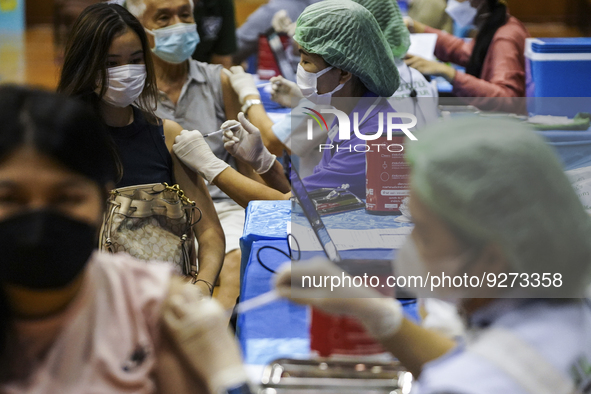 People receive doses of the Pfizer COVID-19 vaccine booster at a vaccination center inside a stadium in Bangkok, Thailand, 03 December 2022....