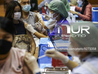 People receive doses of the Pfizer COVID-19 vaccine booster at a vaccination center inside a stadium in Bangkok, Thailand, 03 December 2022....