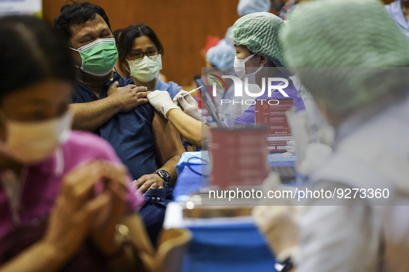 People receive doses of the Pfizer COVID-19 vaccine booster at a vaccination center inside a stadium in Bangkok, Thailand, 03 December 2022....