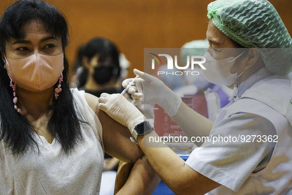 People receive doses of the Pfizer COVID-19 vaccine booster at a vaccination center inside a stadium in Bangkok, Thailand, 03 December 2022....