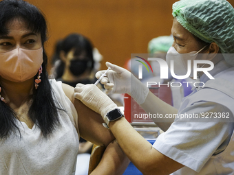 People receive doses of the Pfizer COVID-19 vaccine booster at a vaccination center inside a stadium in Bangkok, Thailand, 03 December 2022....