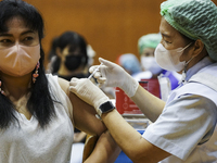 People receive doses of the Pfizer COVID-19 vaccine booster at a vaccination center inside a stadium in Bangkok, Thailand, 03 December 2022....